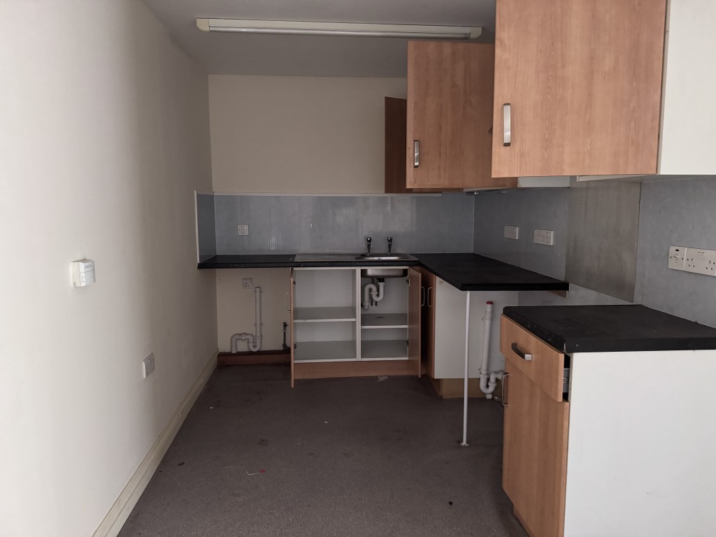 Lot: 9 - TOWN CENTRE BUILDING ARRANGED AS THIRTEEN FLATS IN NEED OF SIGNIFICANT IMPROVEMENT - Kitchen in one of the flats